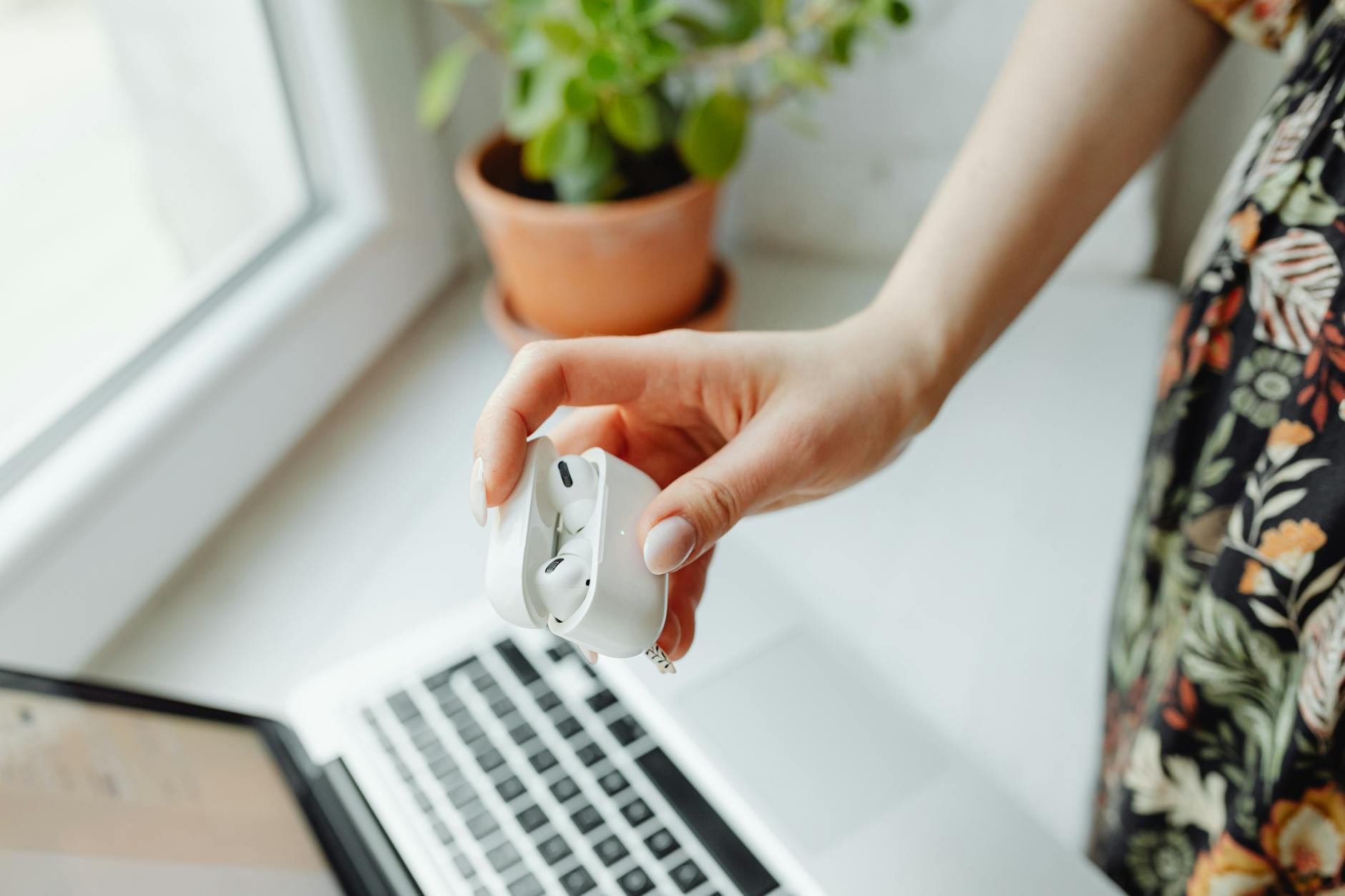 Wireless earbuds on a desk setup with laptop for business calls