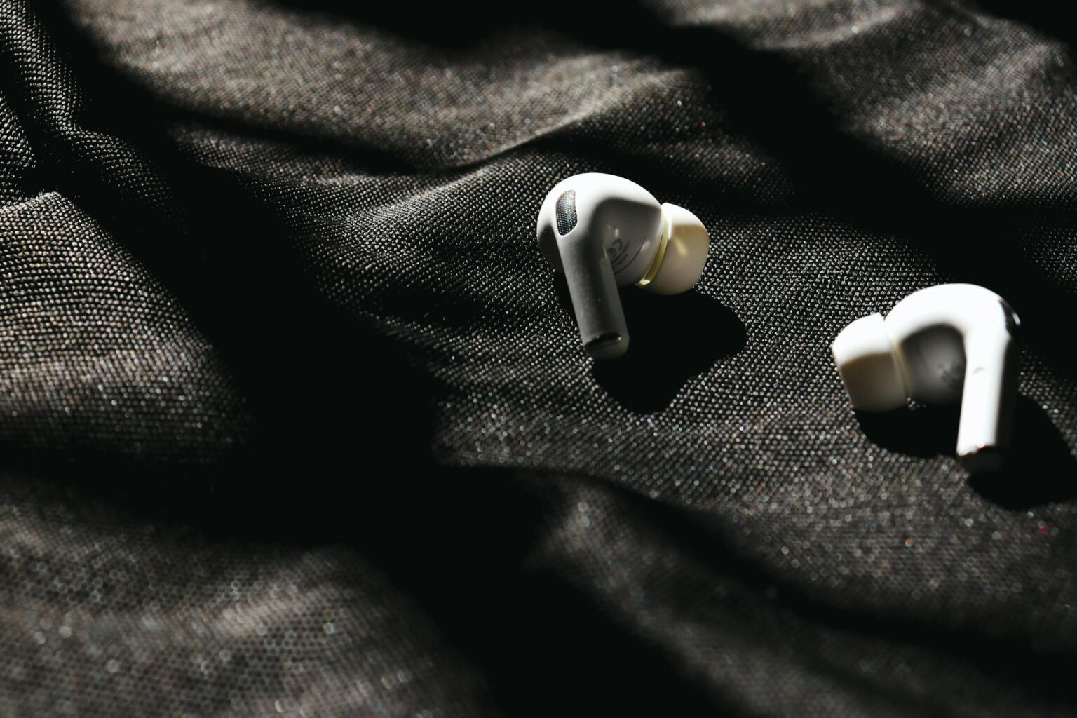White wireless earbuds with charging case on a clean surface