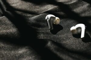 White wireless earbuds with charging case on a clean surface