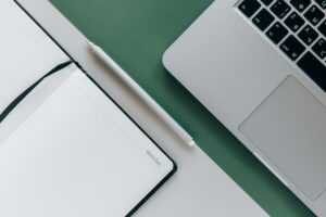 Complete Guide to Obsidian: Advanced Note-Taking and Knowledge Management Person working on laptop with notebook for digital note-taking setup