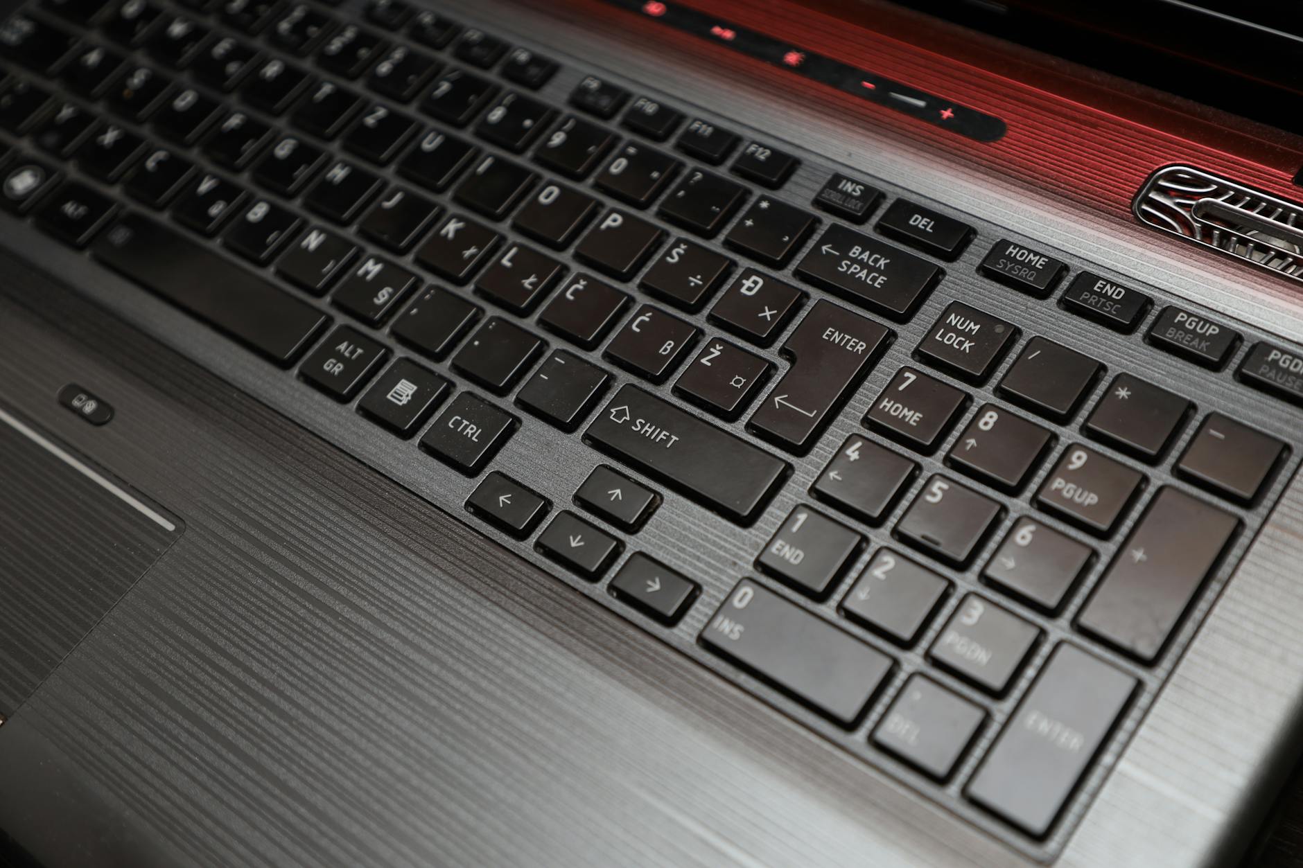 Close-up view of a modern laptop keyboard with backlit keys, representing developer-focused laptop design