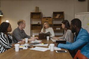 Business team collaborating around a conference table with laptops and documents