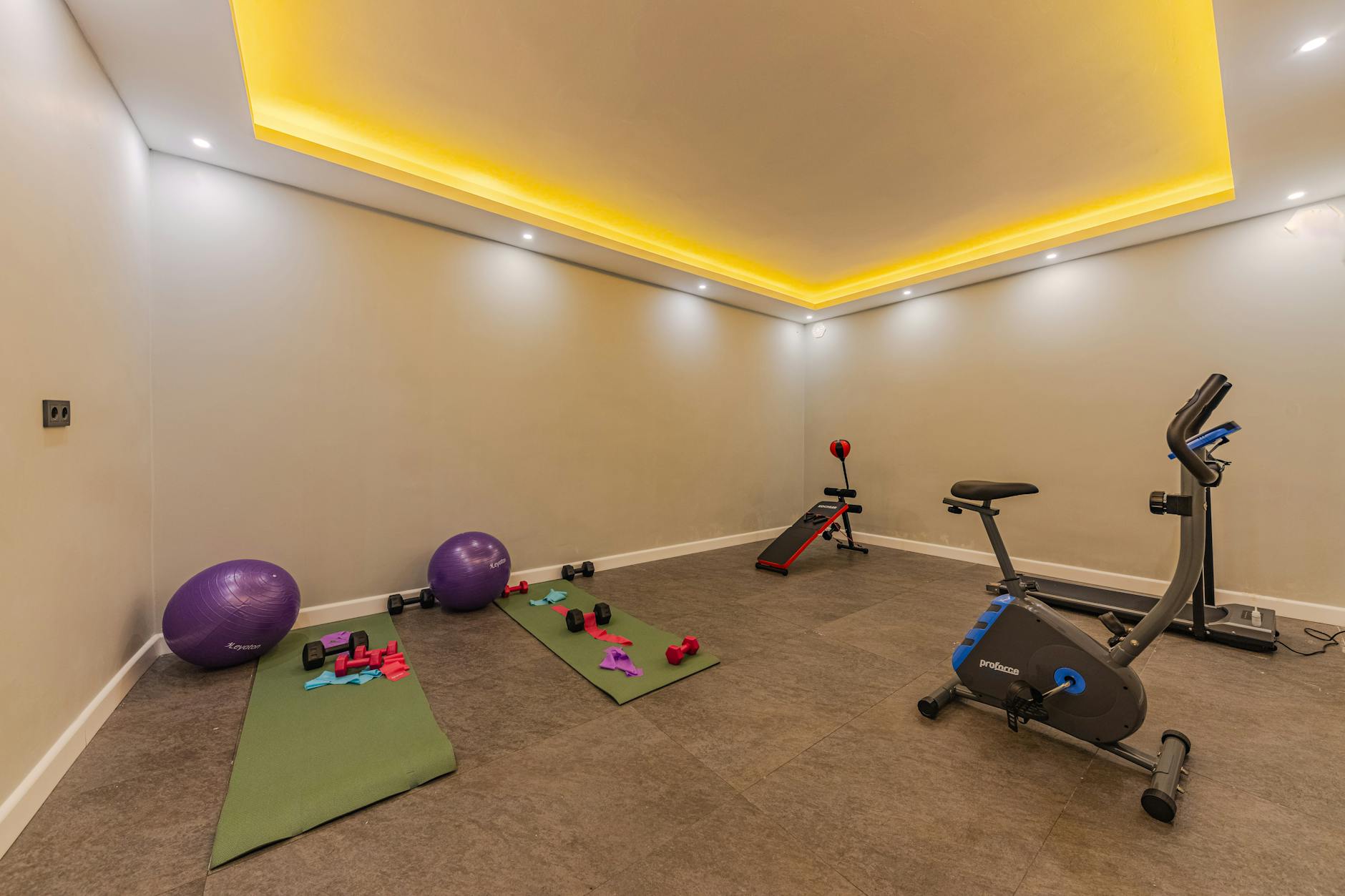 Modern home gym setup with smart fitness equipment and large display screen