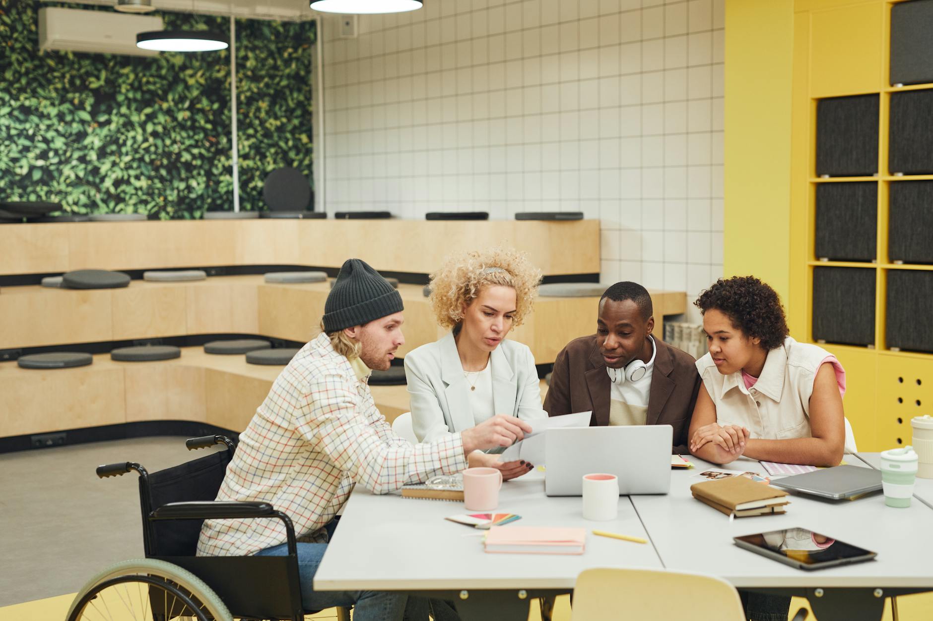 Business team collaborating around table with laptops and documents during meeting