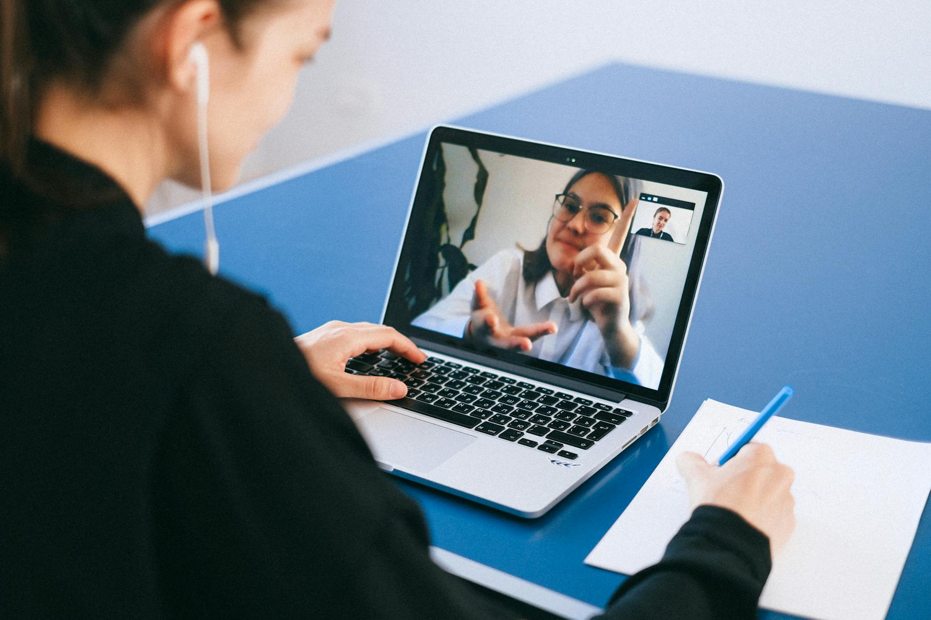 Person participating in video conference call wearing wireless earbuds