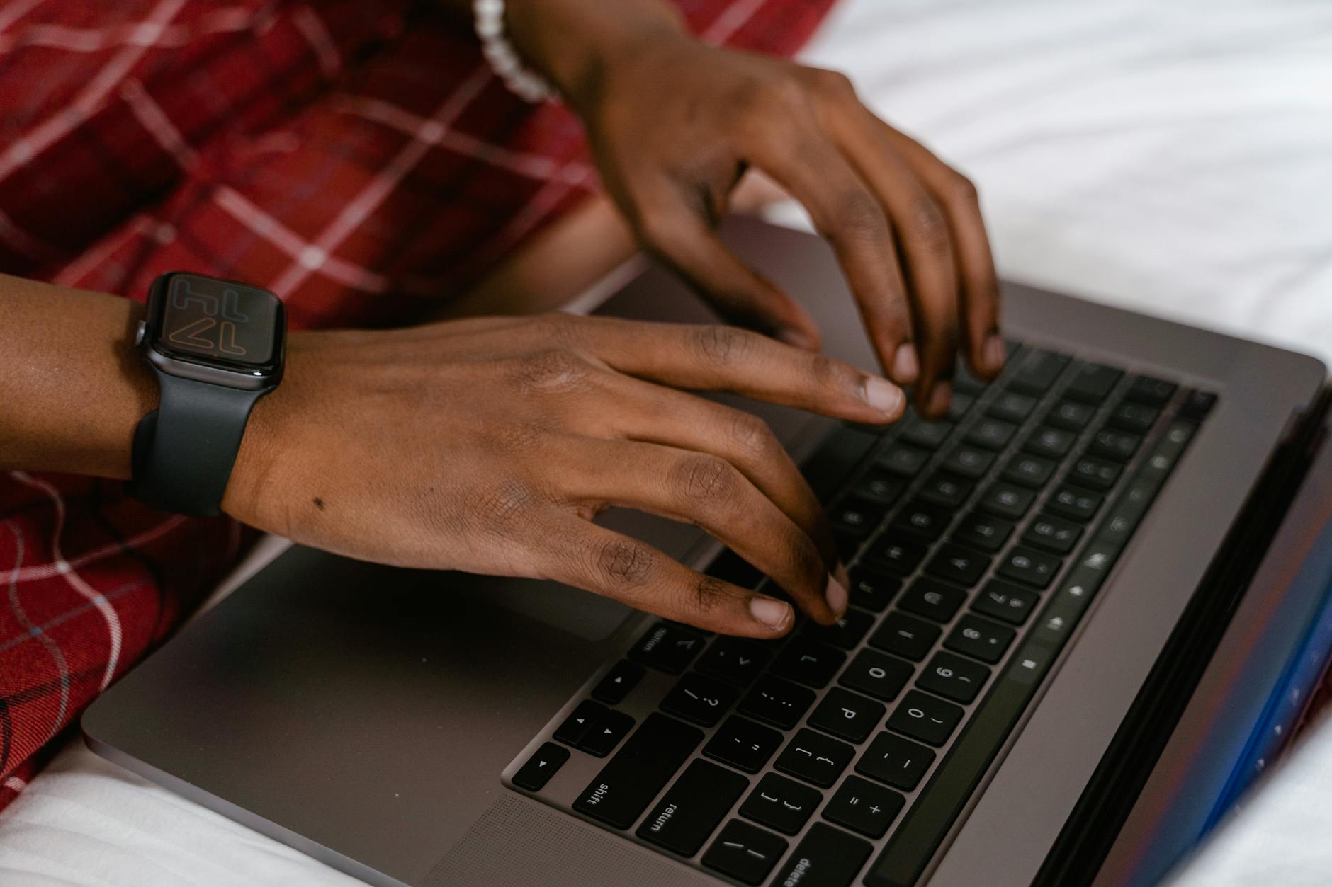 Student hands typing on laptop keyboard in study environment