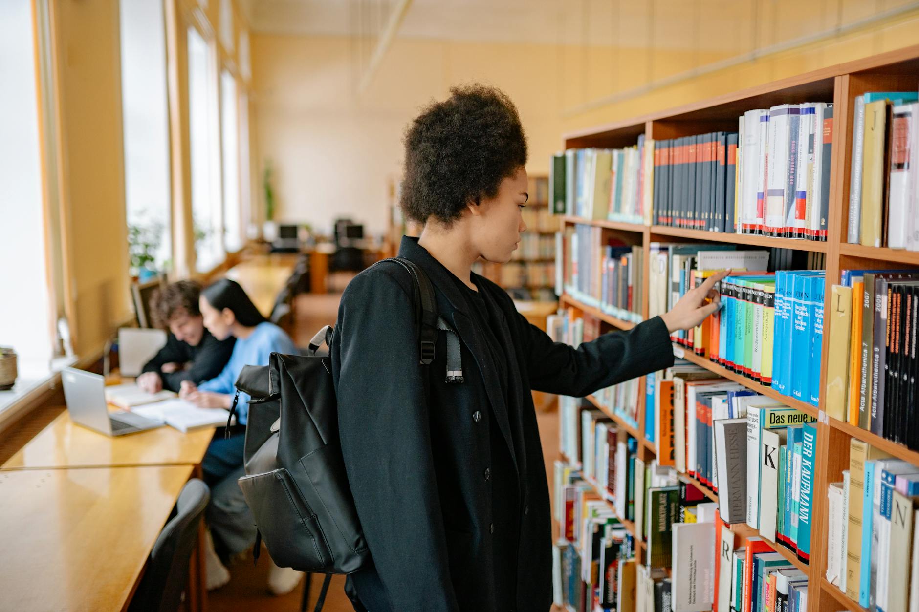 University student studying with laptop in modern library environment