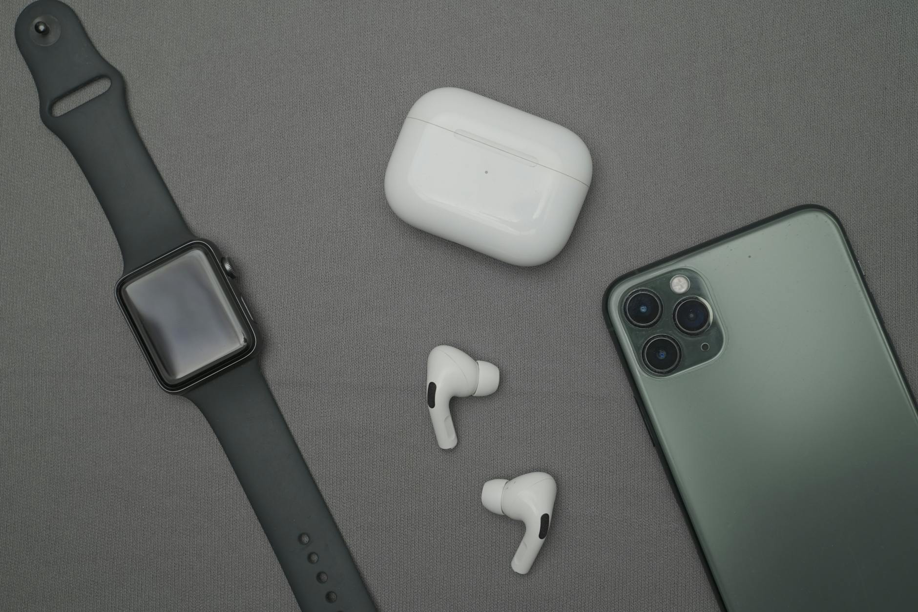 Premium wireless earbuds and smartphone arranged on modern desk