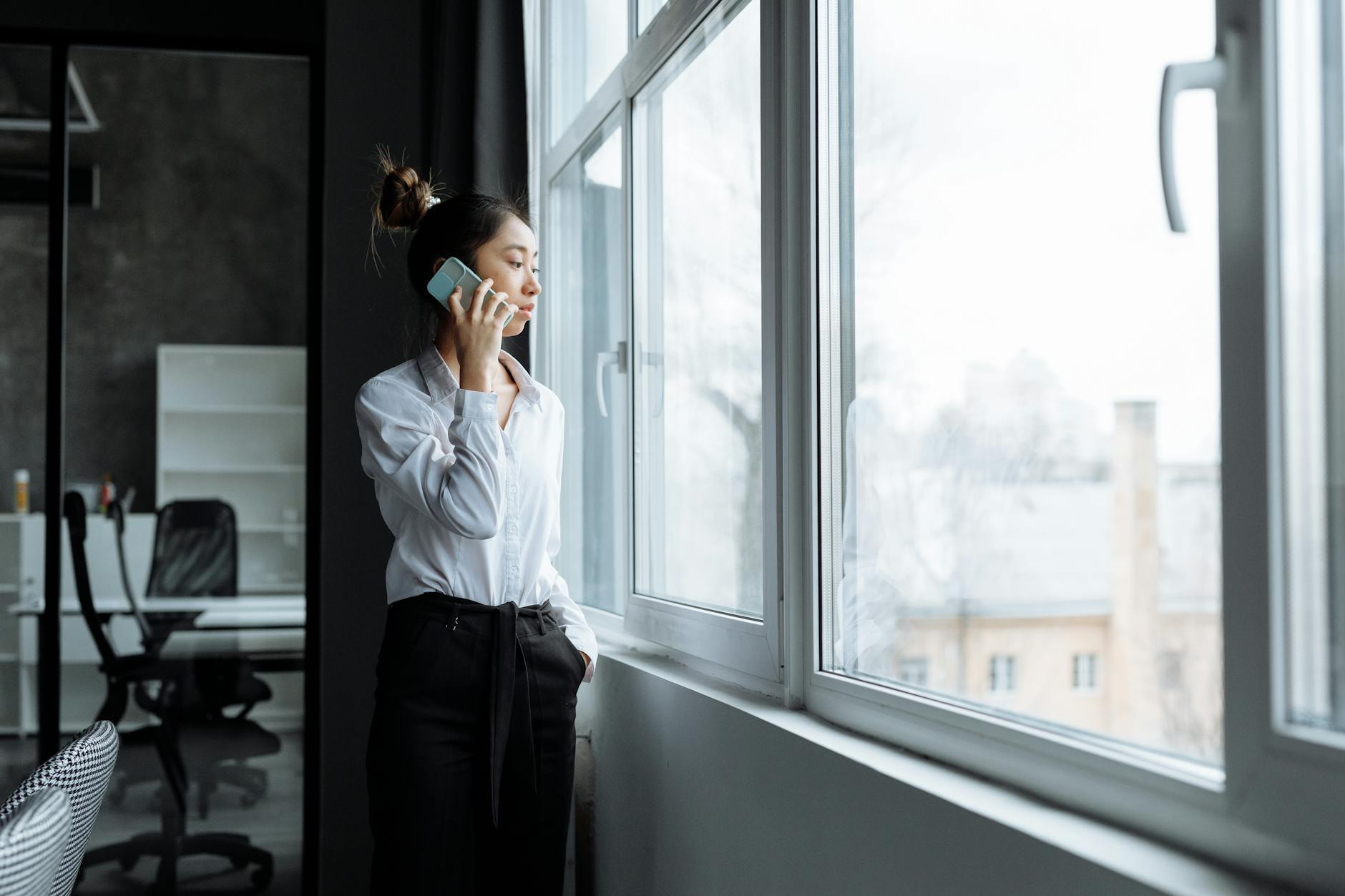 Professional taking business phone call with wireless earbuds in office environment