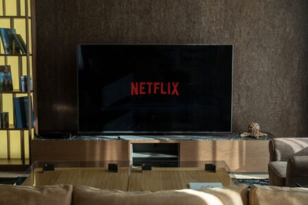 A modern living room home theater setup with a large TV and soundbar on a media console