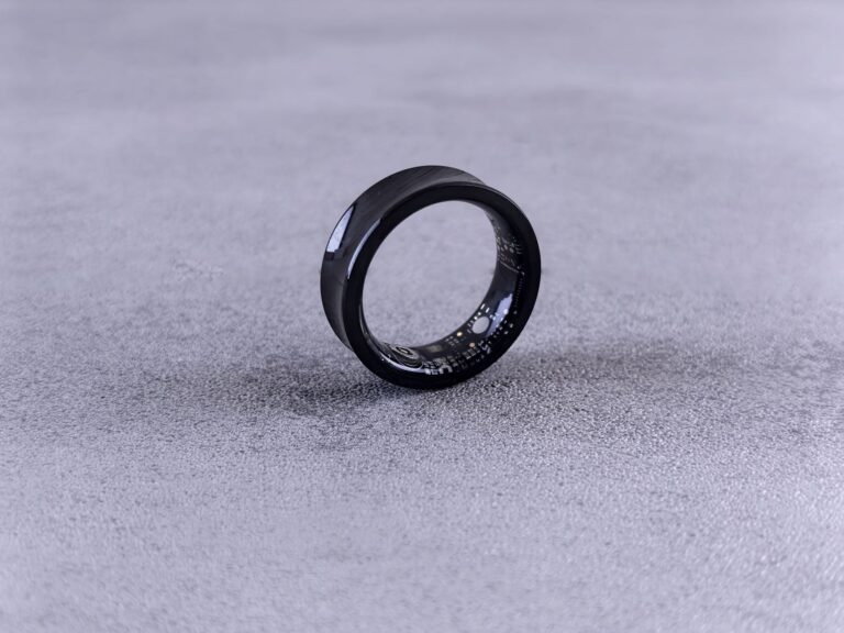 Close-up of a smart ring worn on a finger showing health tracking device design