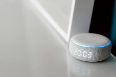 Modern smart home devices and control panel setup on wooden desk