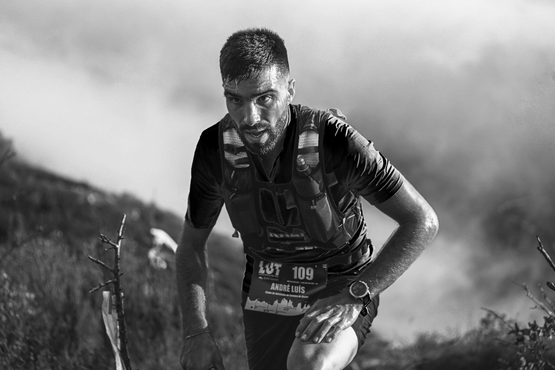 Trail runner checking a GPS smartwatch during a mountain run