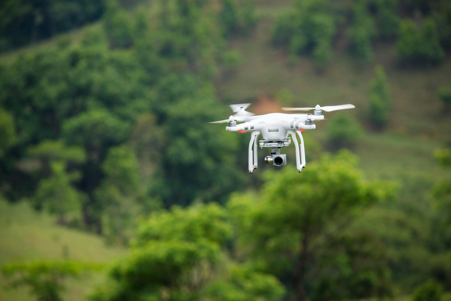 Small drone capturing aerial footage over open landscape