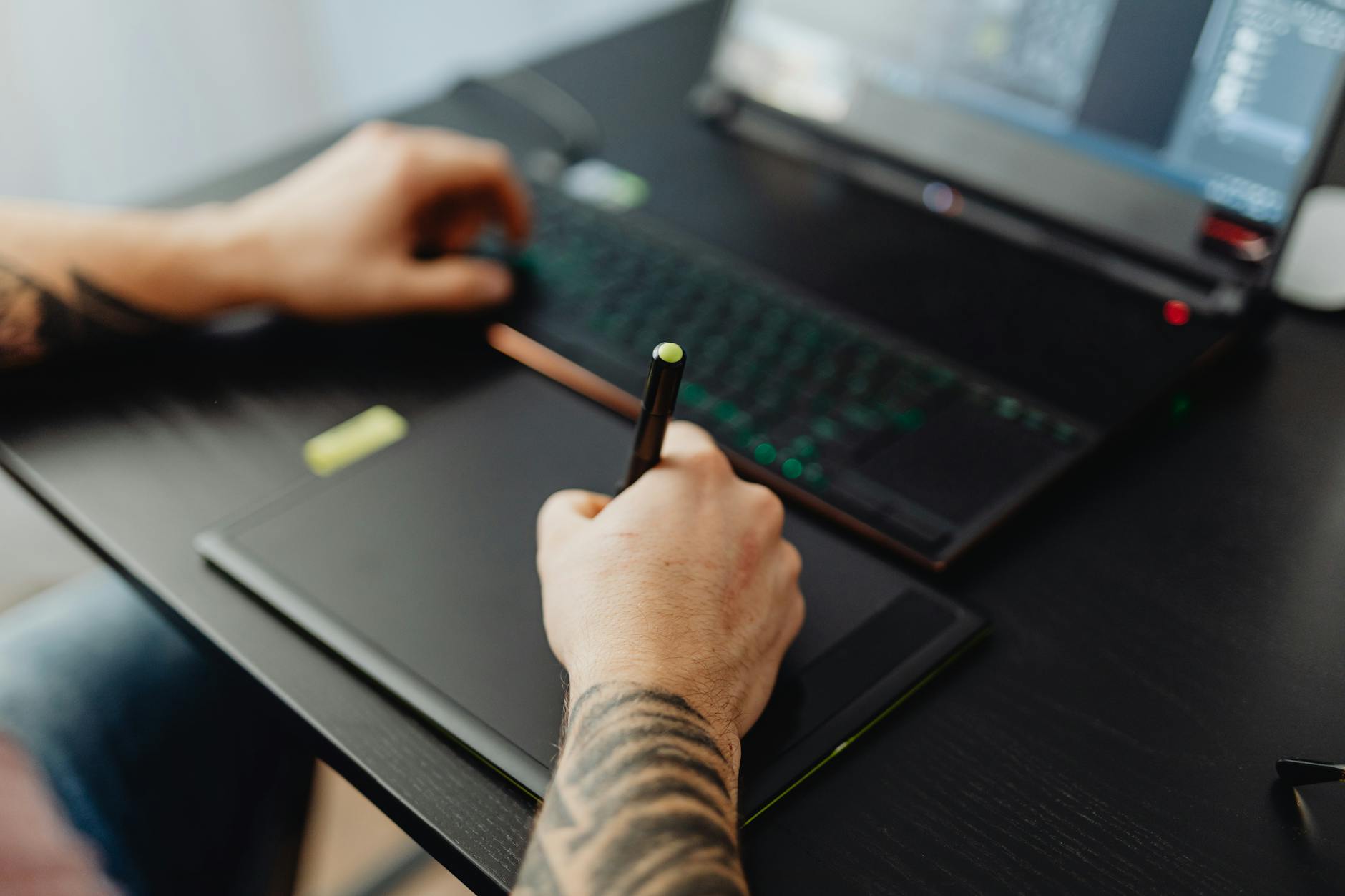 Professional animator working at computer with 3D character model visible on screen
