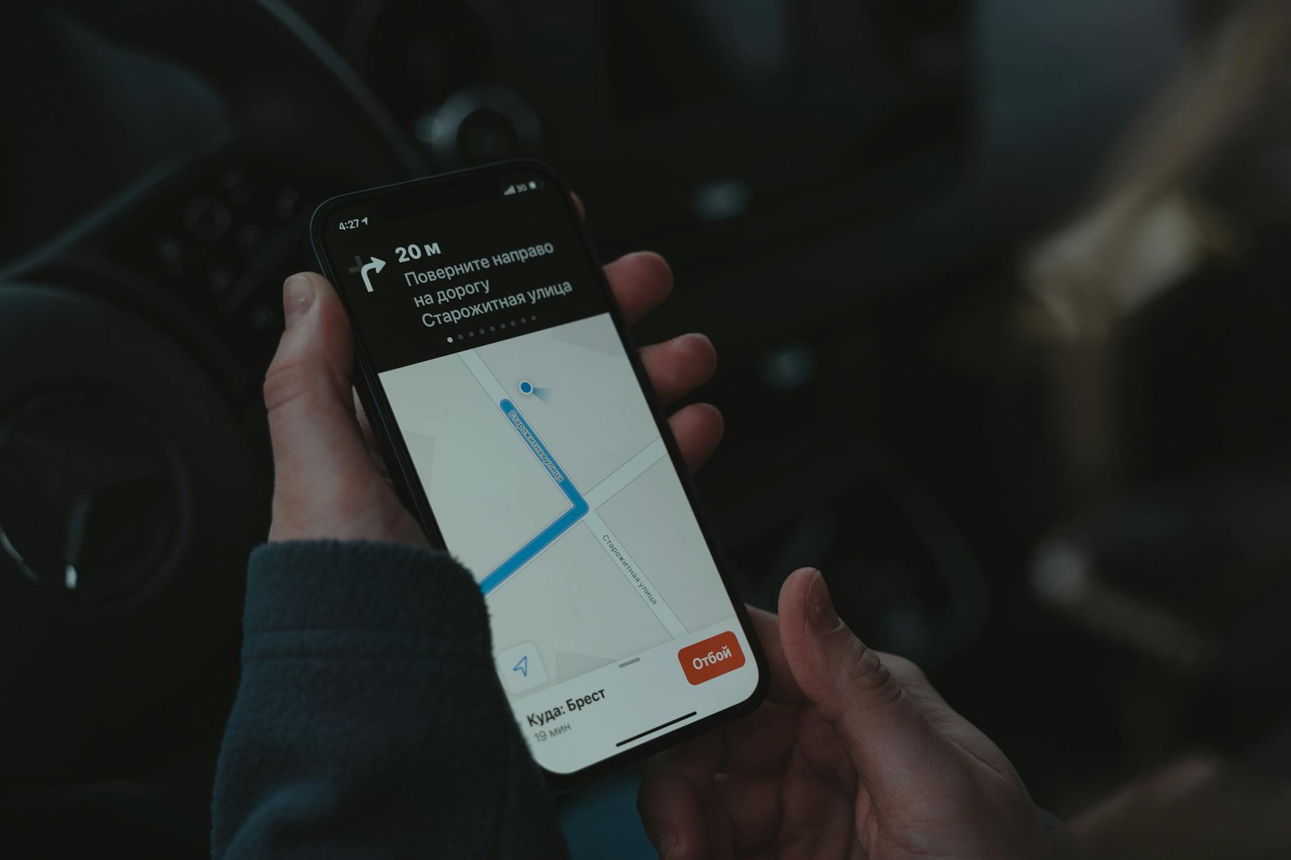 Hand holding smartphone showing home automation app interface with device controls