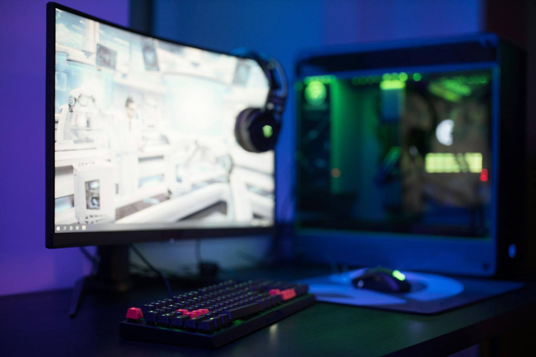 Gaming computer setup with RGB lighting showing performance monitoring software on screen