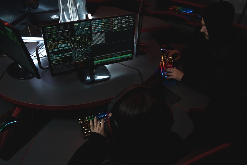 Set Up Bitwarden Secrets Manager for Team Credential Sharing A developer managing security credentials on a laptop with a team in the background