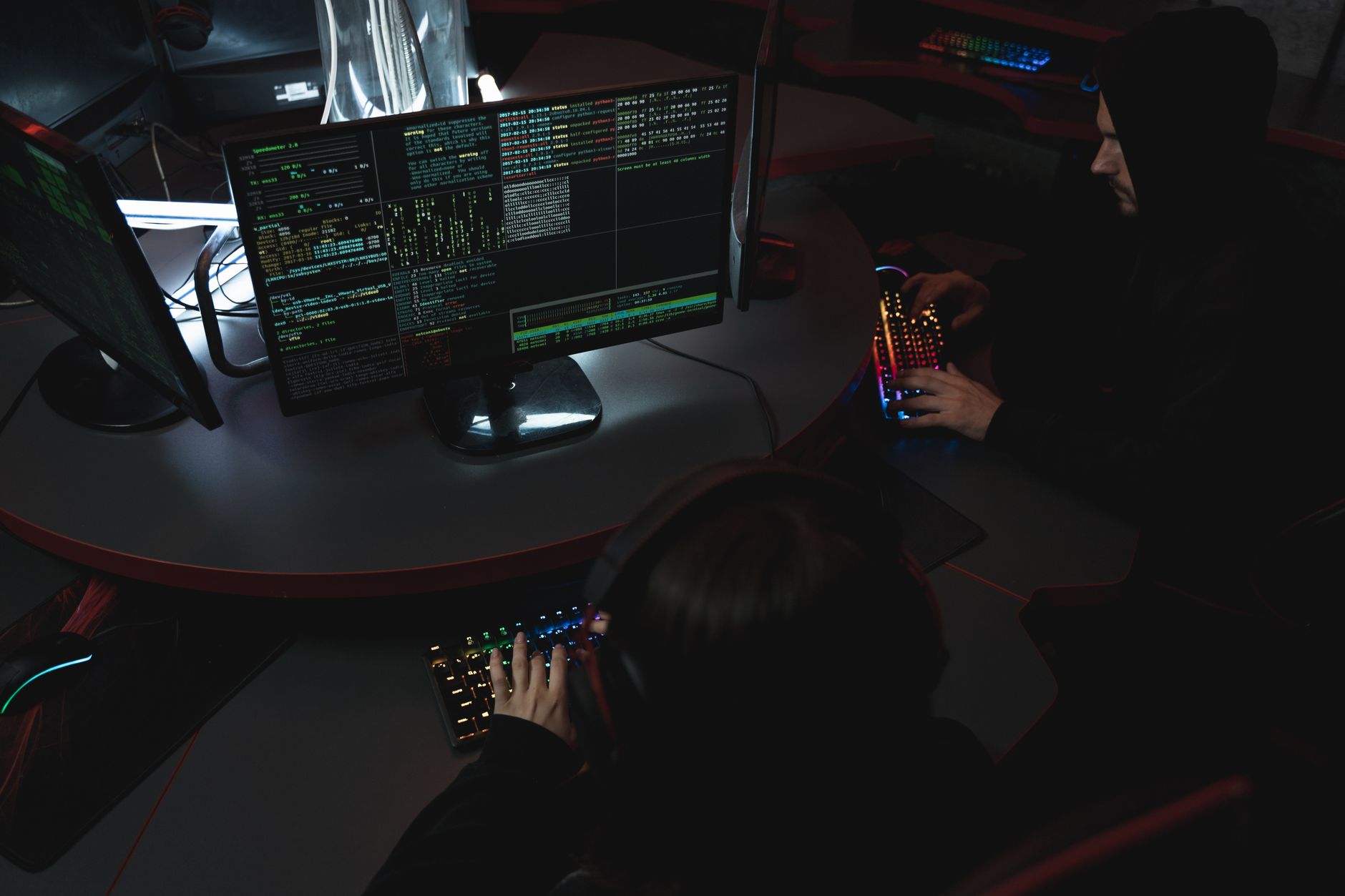A developer managing security credentials on a laptop with a team in the background