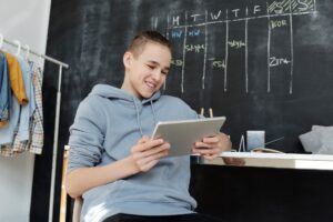 reMarkable Paper Pro vs Kindle Scribe: Best E-Ink Tablet Person writing on an e-ink tablet with a stylus on a desk
