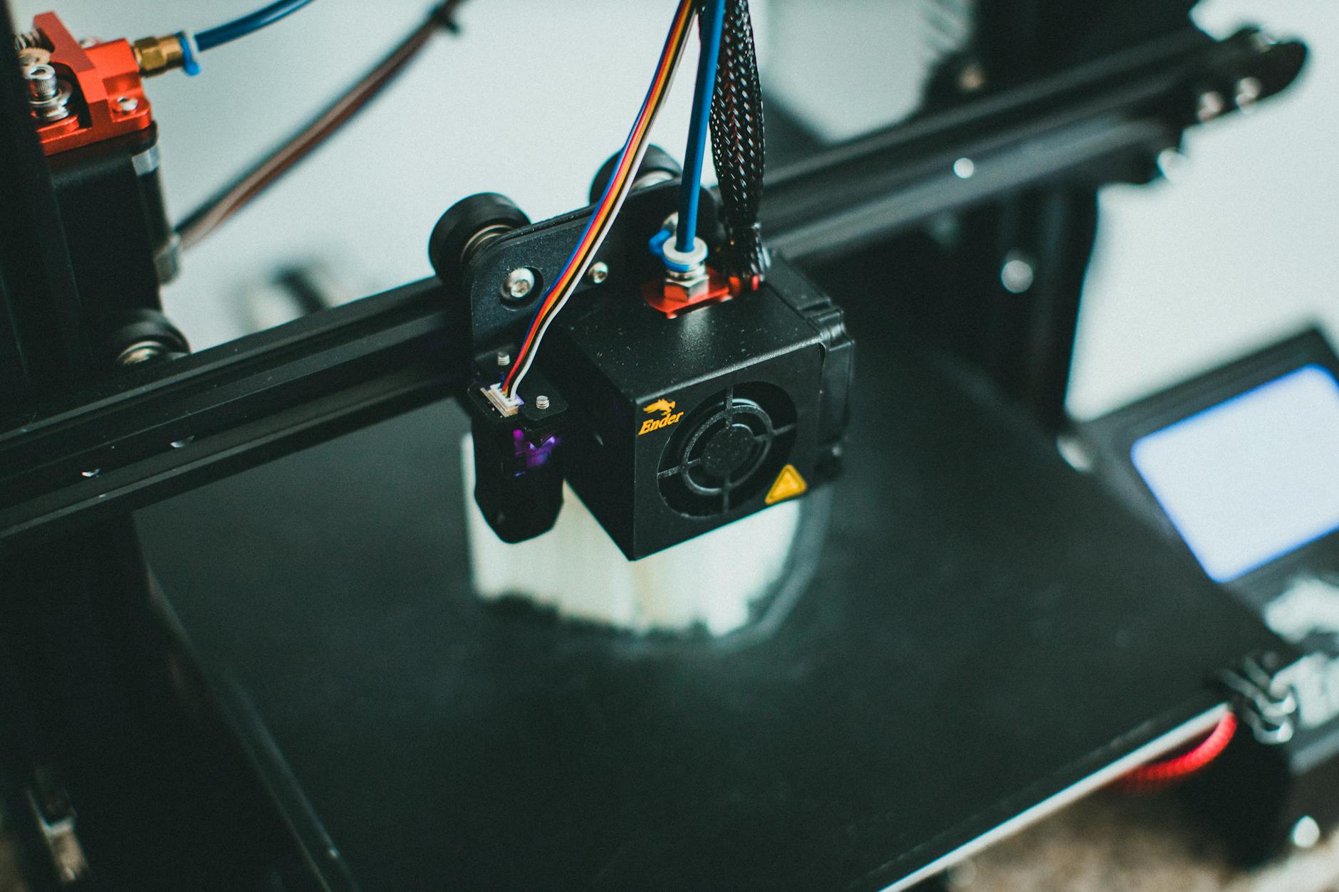 Colorful spools of 3D printing filament arranged on a workshop shelf