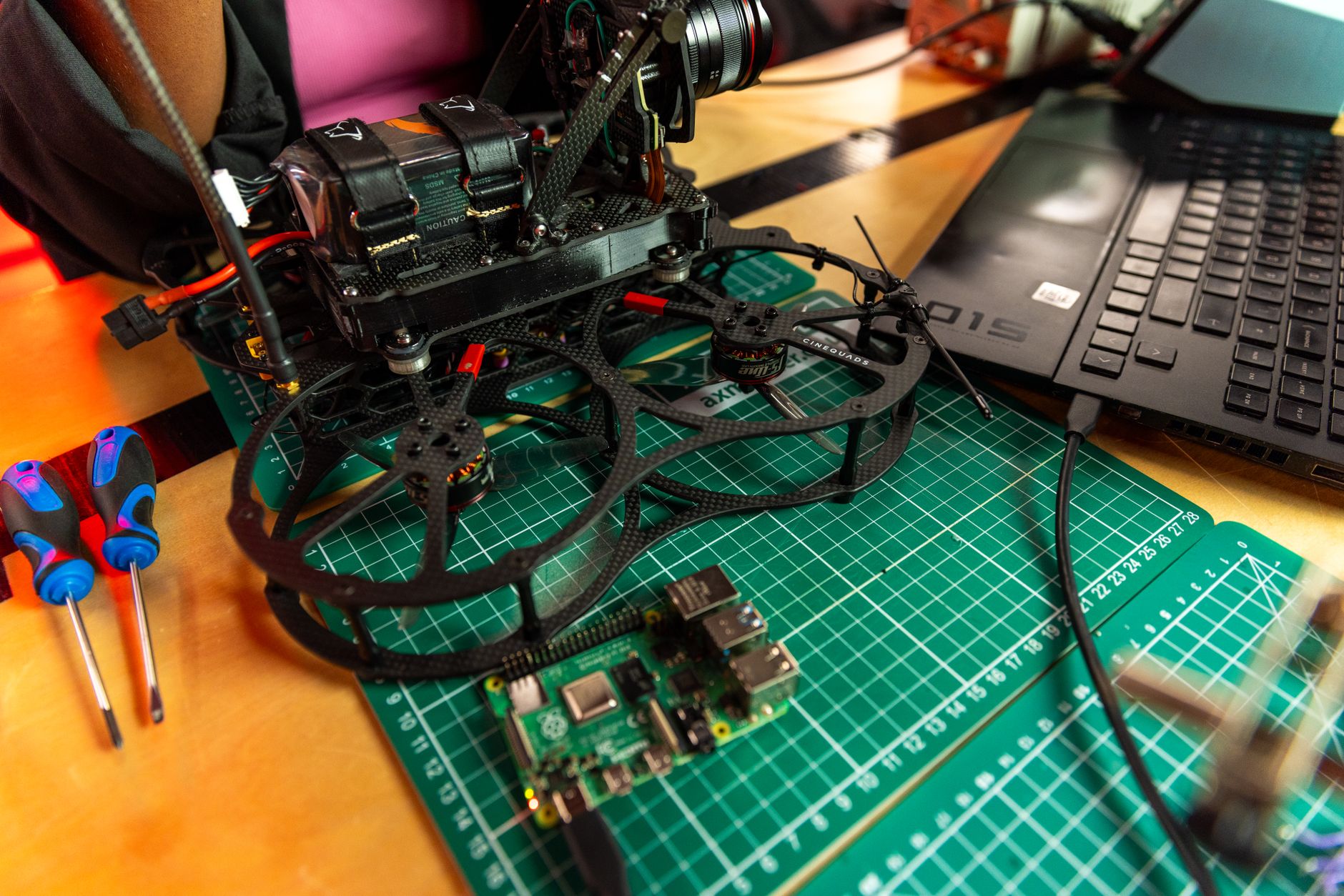 A Raspberry Pi single-board computer connected to cables on a workbench