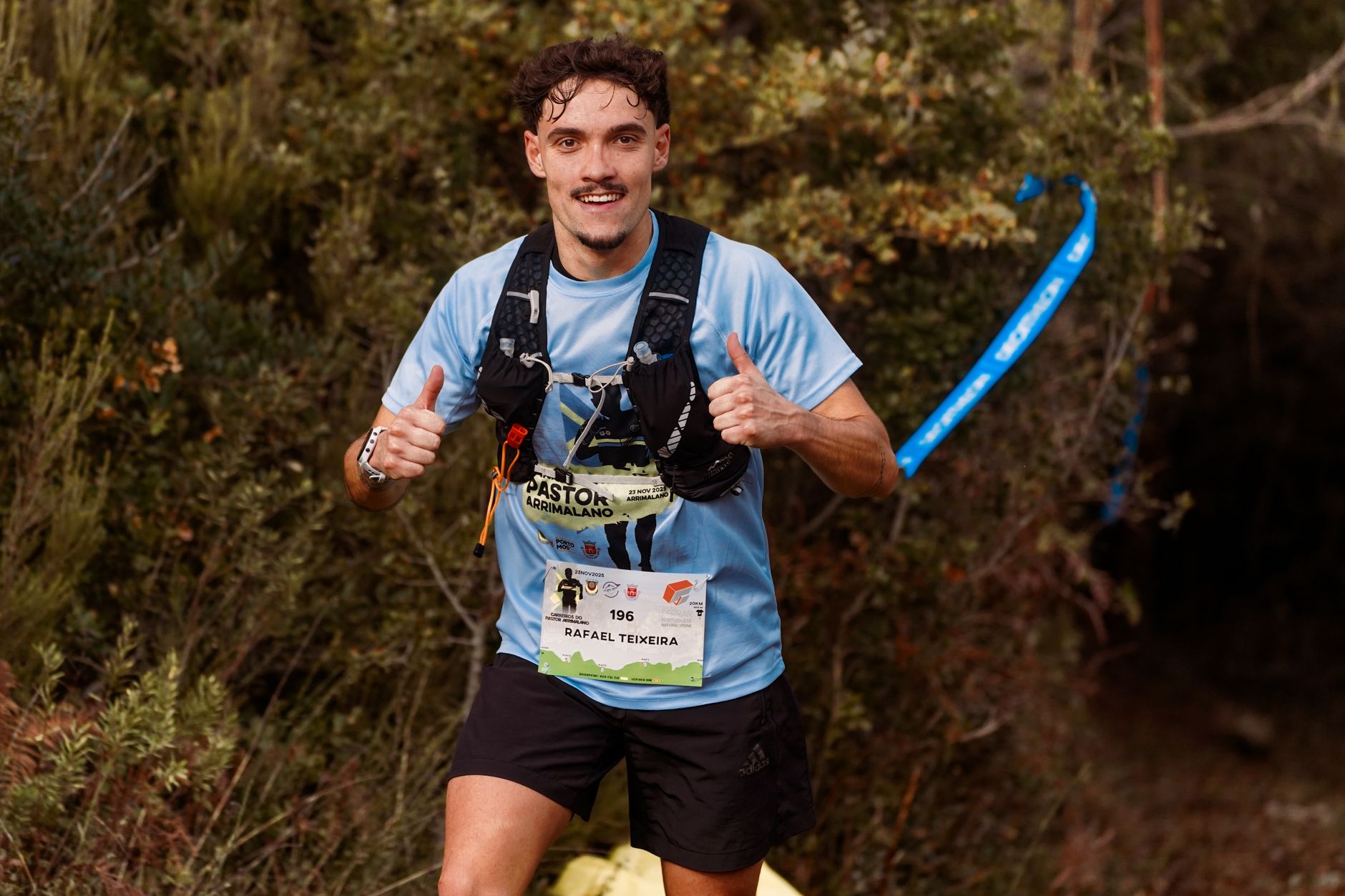 Runner checking GPS watch during a trail run through mountainous terrain