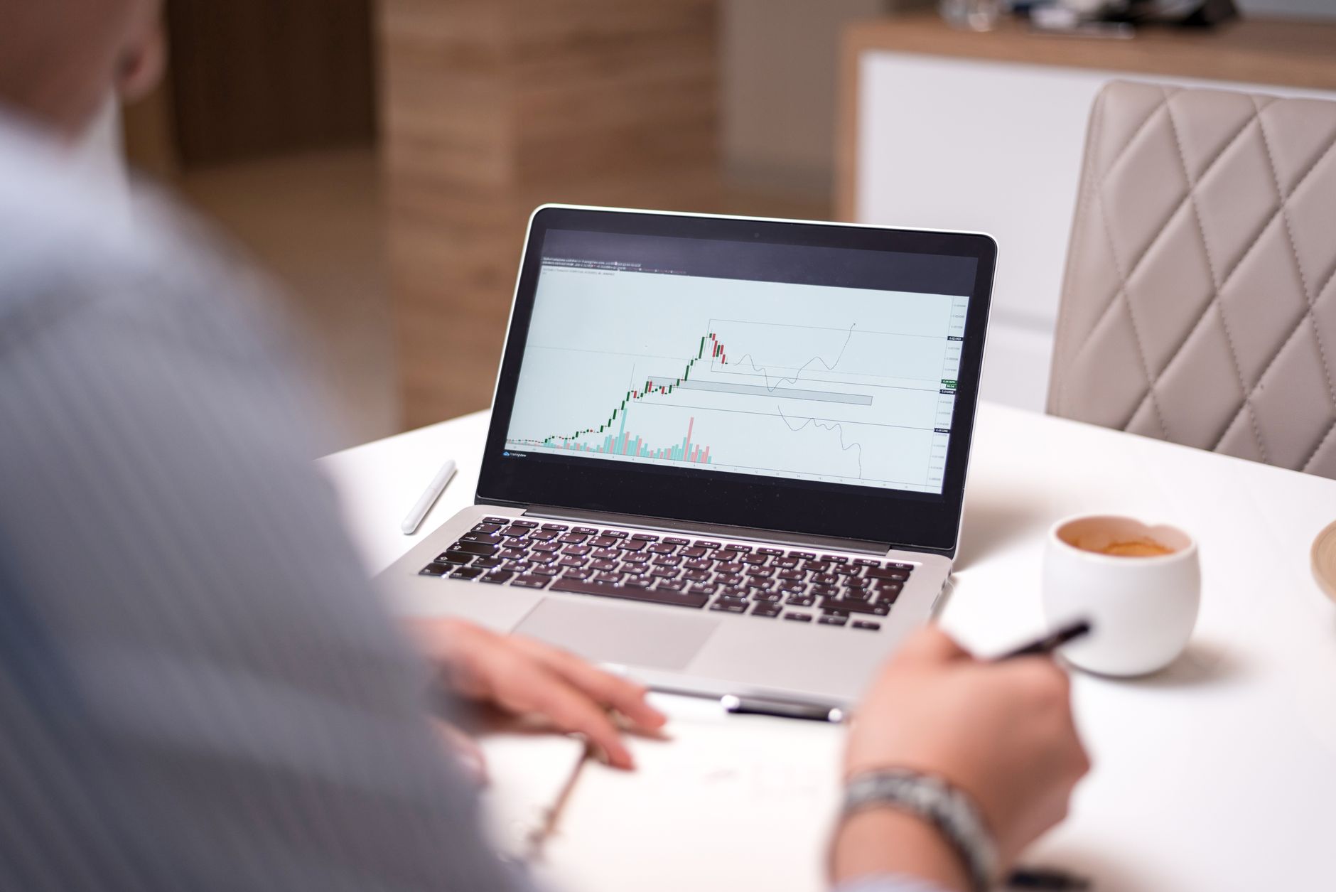 Laptop displaying a finance tracking interface on a home desk