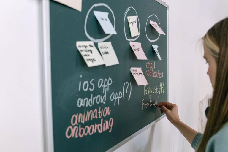 A physical Kanban board with colorful sticky notes organized in columns representing a project workflow