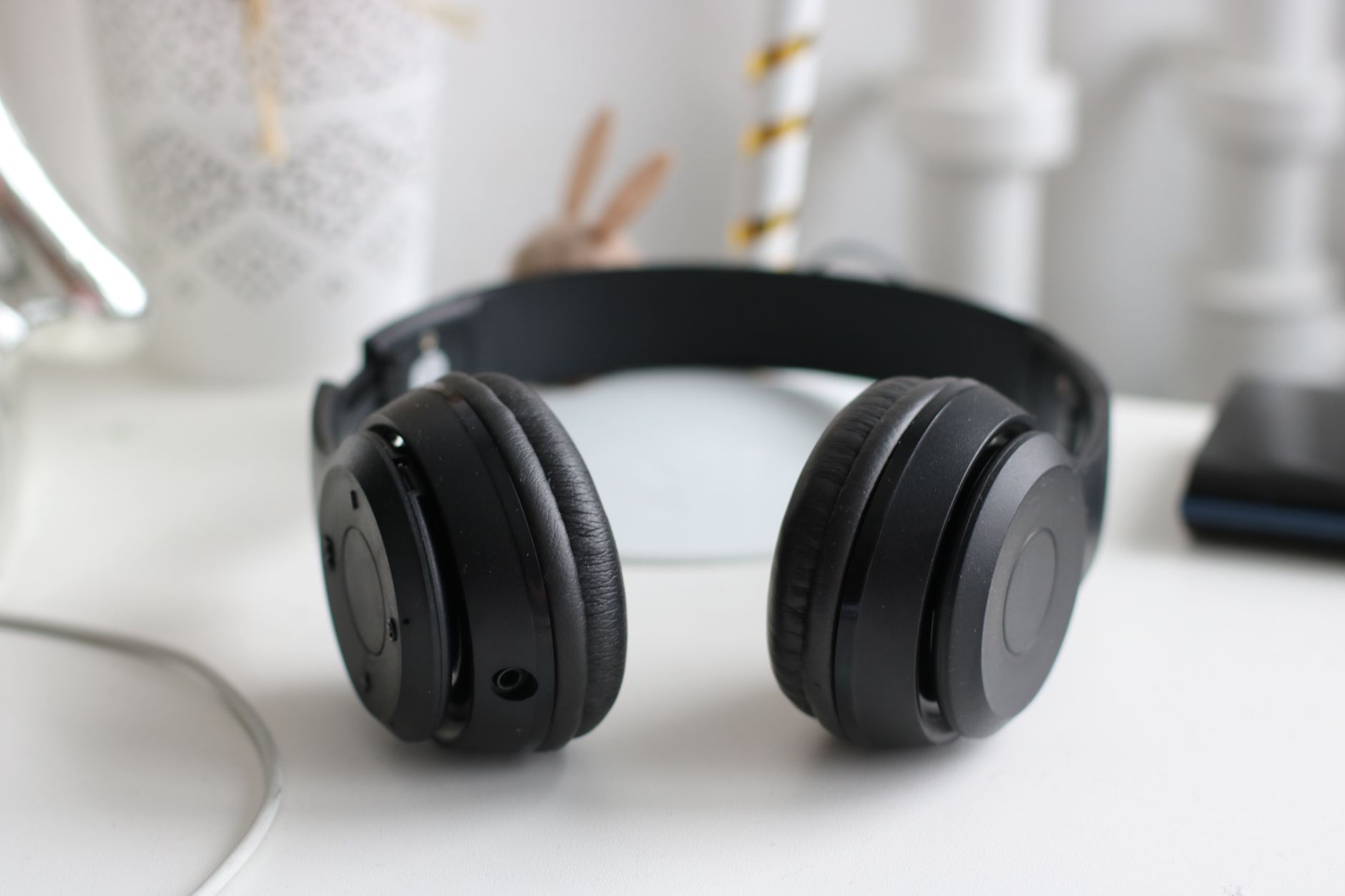 Headphones resting on a desk next to a computer, representing music playback after library organization