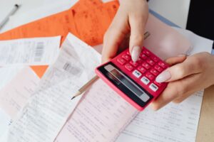 Set Up Wallos as a Self-Hosted Subscription Tracker Stack of receipts and bills on a desk representing recurring subscription costs