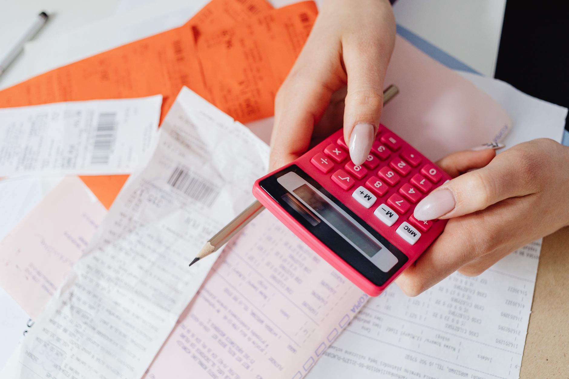 Stack of receipts and bills on a desk representing recurring subscription costs