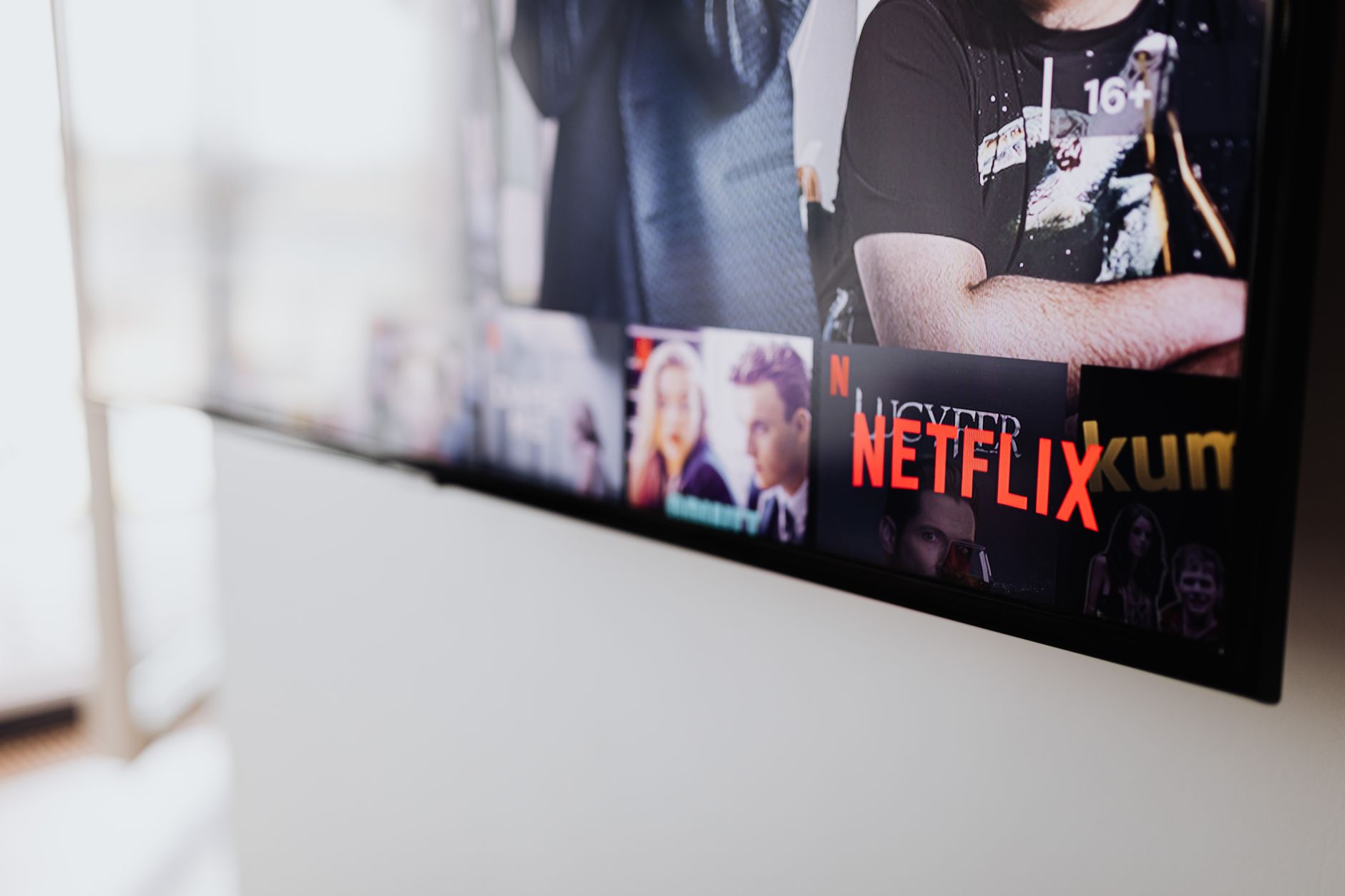 A television screen displaying a streaming library with organized show thumbnails