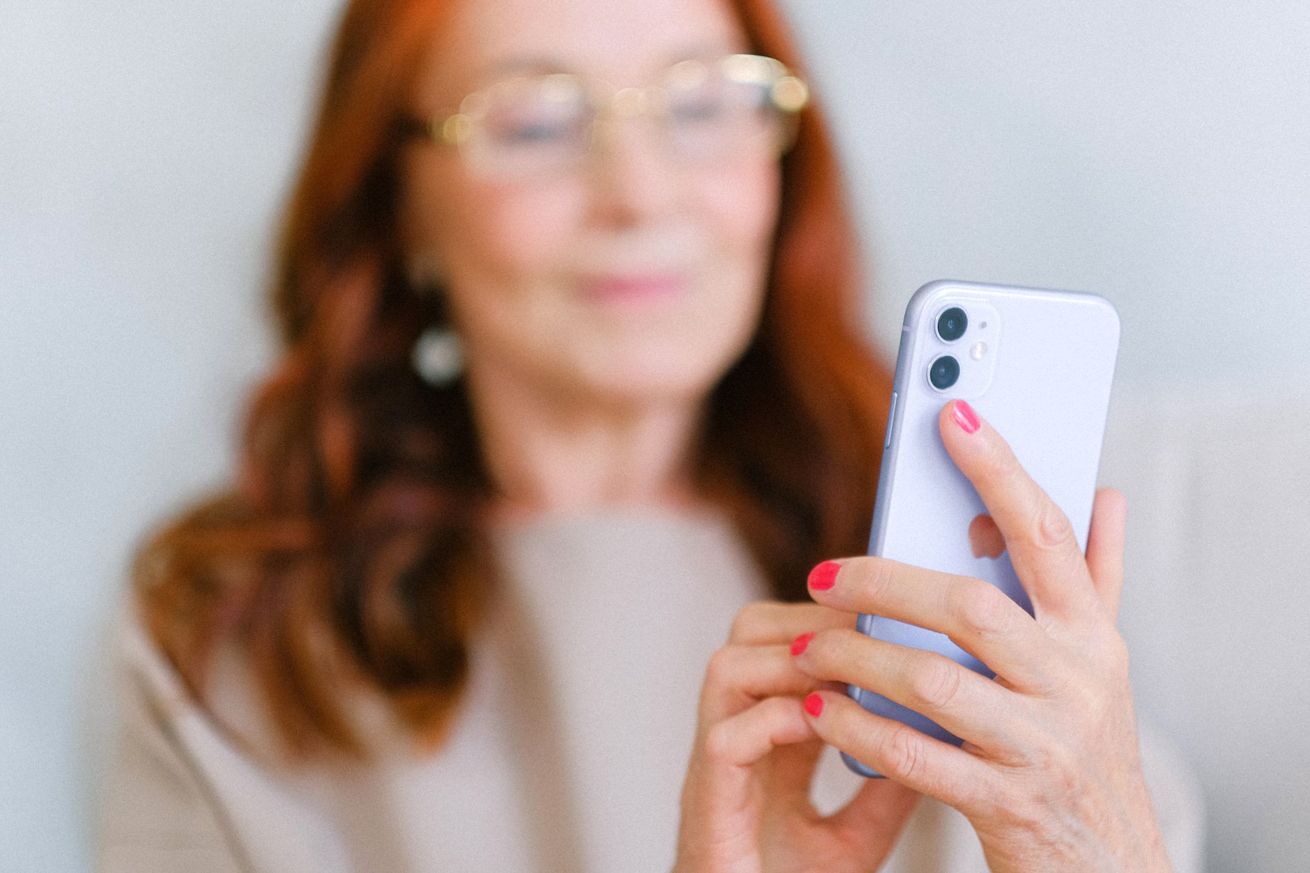 Person reading news on a mobile phone representing FreshRSS synced with a mobile RSS app