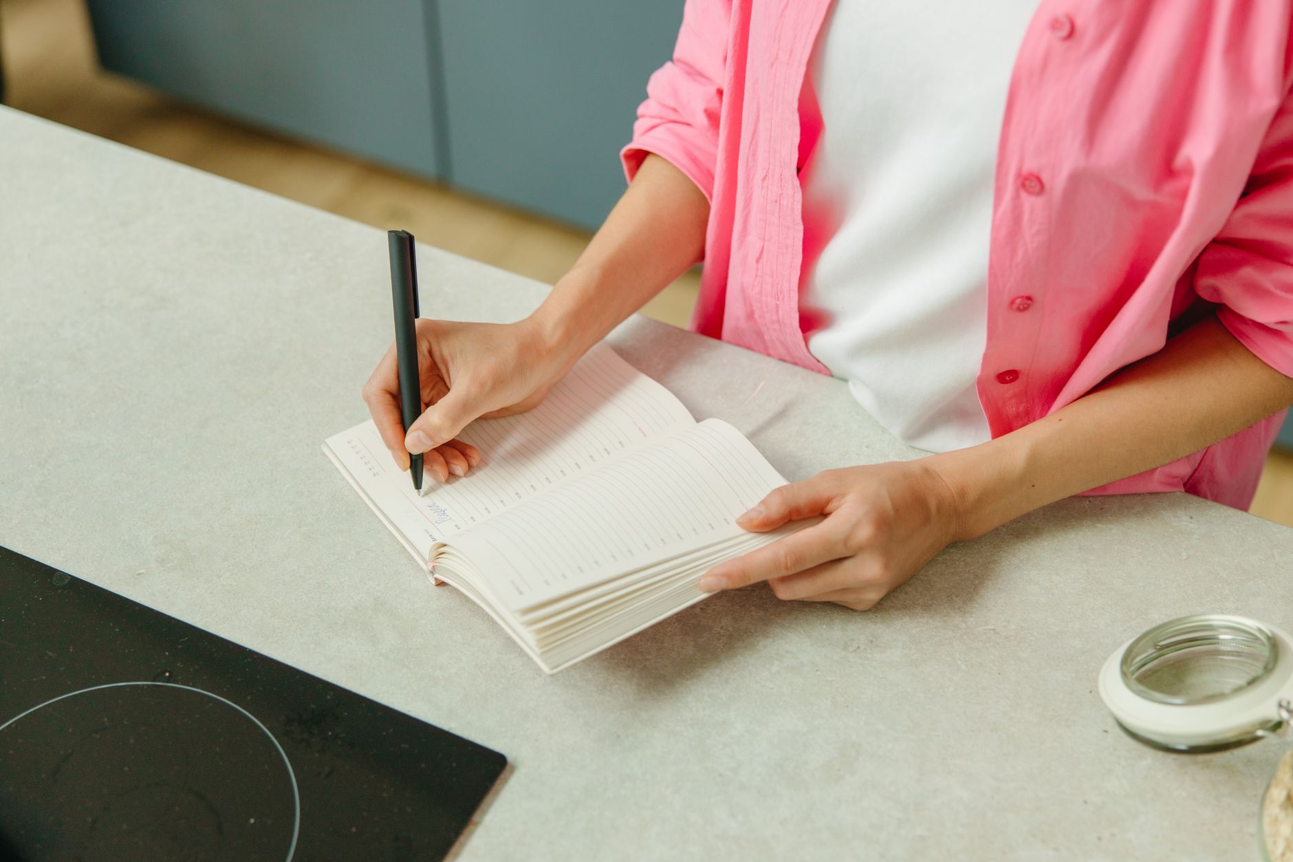 Meal planning notebook open on a table with a pen beside it
