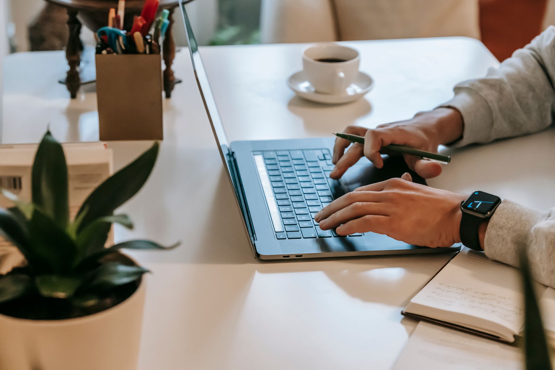 Person using a laptop at a home desk to manage digital accounts