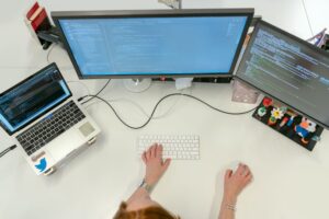 A developer working at a desk with multiple monitors showing code