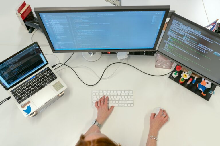 A developer working at a desk with multiple monitors showing code